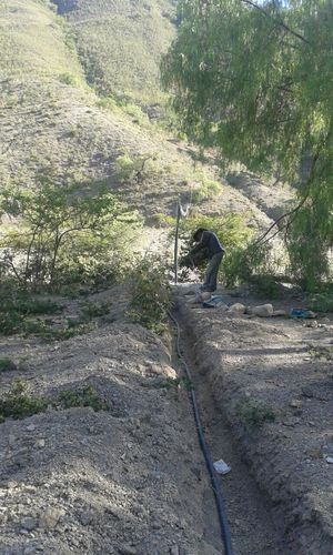 Mitte Bild führt die Leitung über den Fluss,<br>der nur in der Regenzeit stossweise Wasser führt.